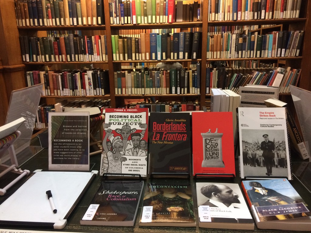 Skyltning av böcker på ett bord i ett bibliotek med tema dekolonisering. 